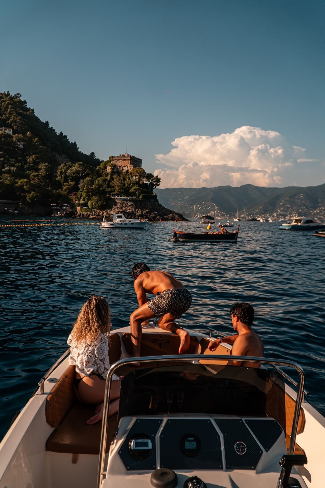 Ospiti a bordo davanti a Portofino al tramonto